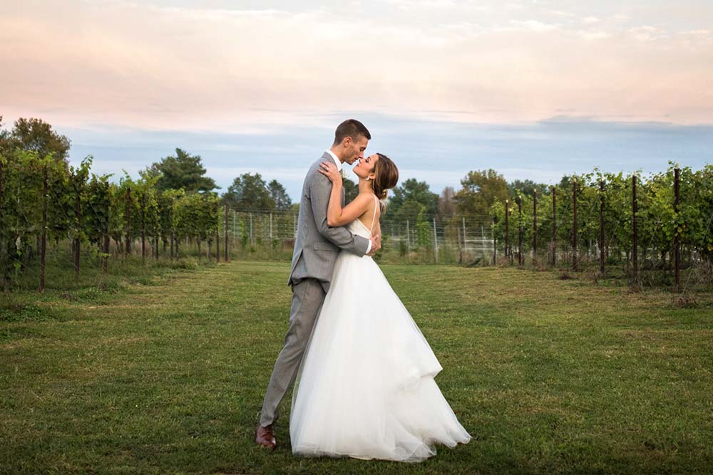 Wedding couple posing for a picture in the vineyard