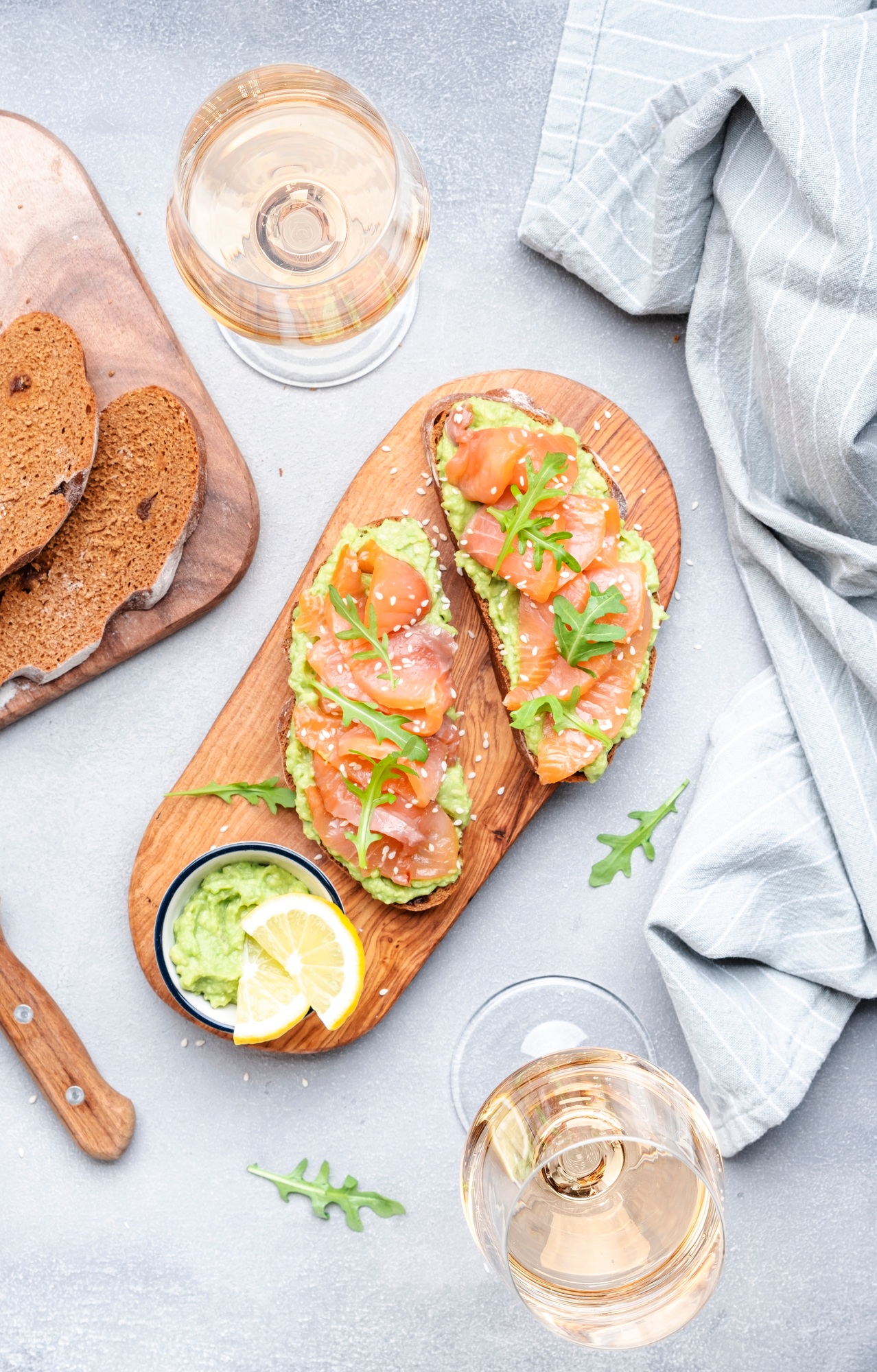 Gourmet lunch with avocado salmon toasts on rye bread and rose wine glasses
